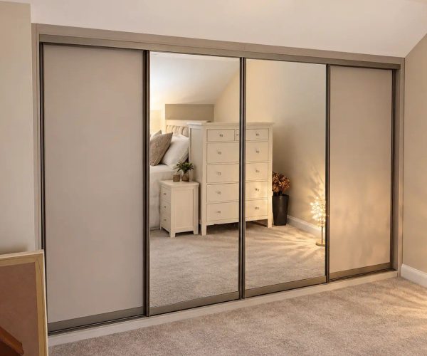 Floor-to-ceiling mirrored sliding wardrobe with slim silver frames, creating a bright and spacious feel in a modern bedroom.