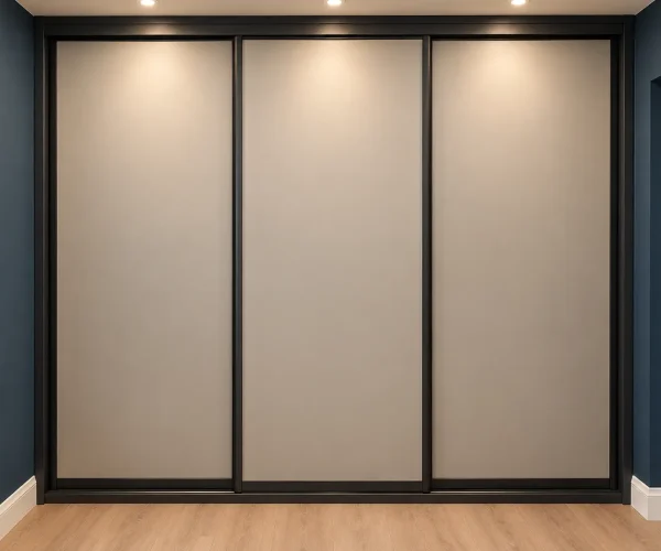 Contemporary greige sliding wardrobe doors with slim black frames, fitted across a bedroom wall beneath recessed ceiling spotlights.